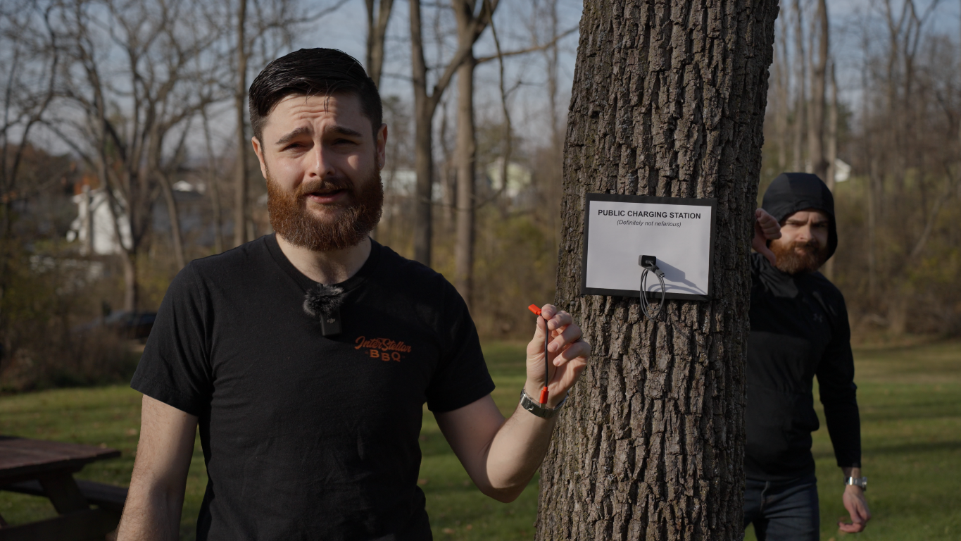 David talking about juice jacking while evil David is standing behind tree.